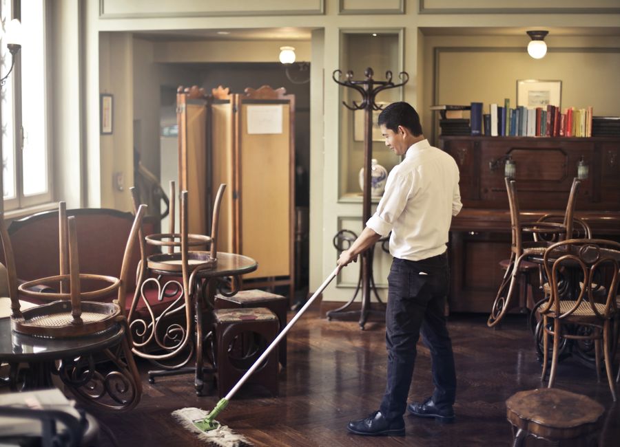 Operario fregando el suelo de un local de hostelería